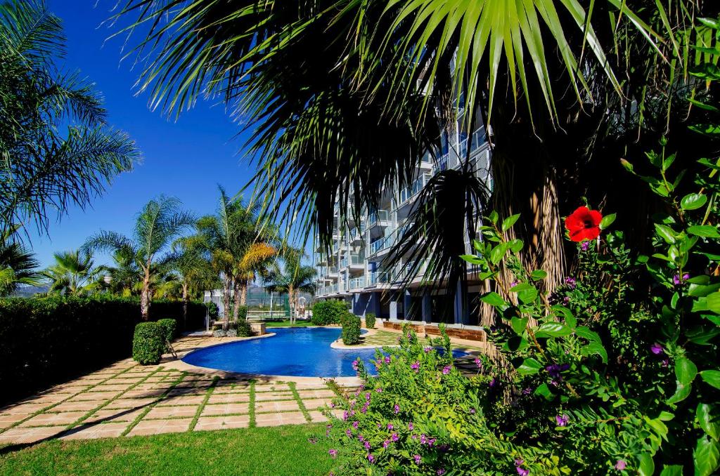 un complejo con piscina y palmeras en Chill'n Holidays, en Moncófar