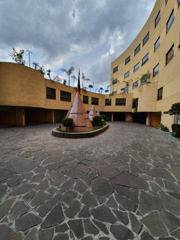 a building with a statue in the middle of a courtyard at HOTEL VALLE DEL SUR in Mexico City