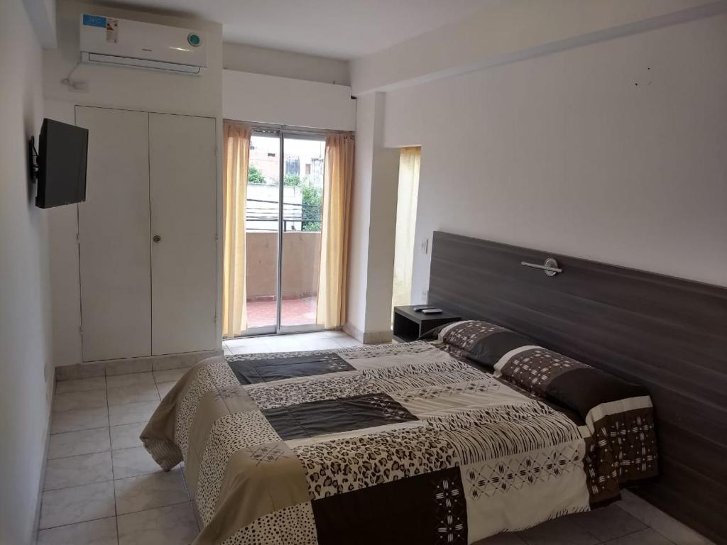 a bedroom with a bed and a large window at Premier in Santiago del Estero