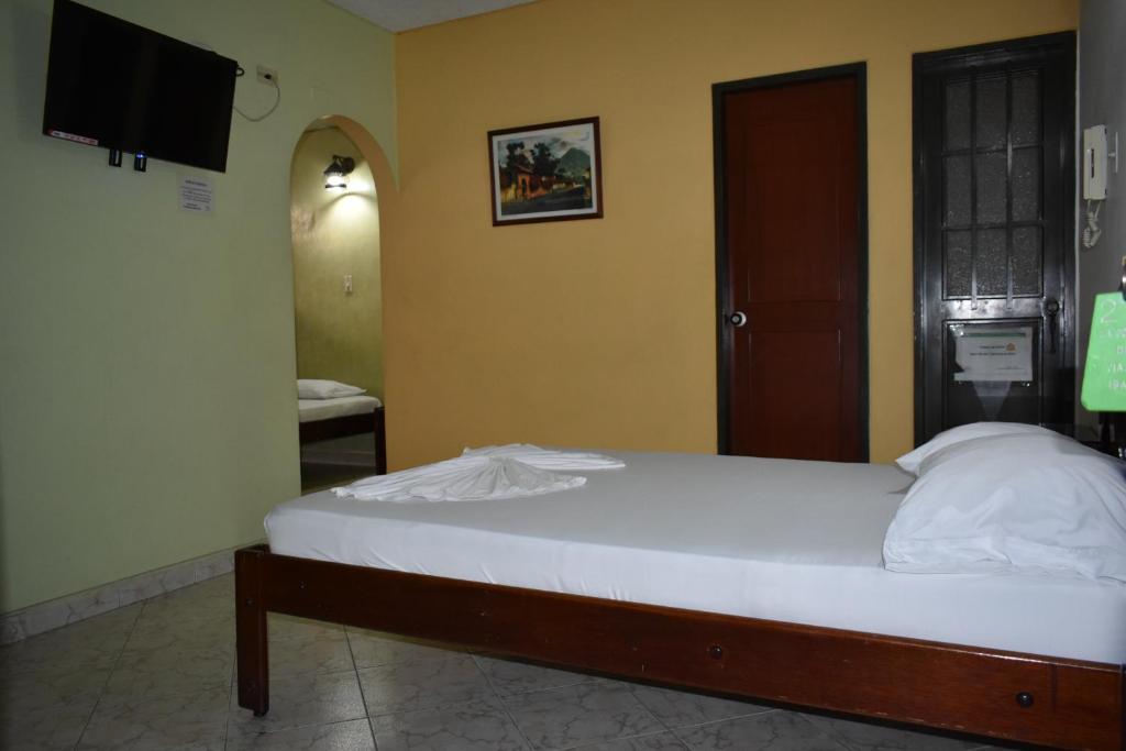a bedroom with a bed and a television in a room at LA POSADA DEL VIAJERO in Ibagué