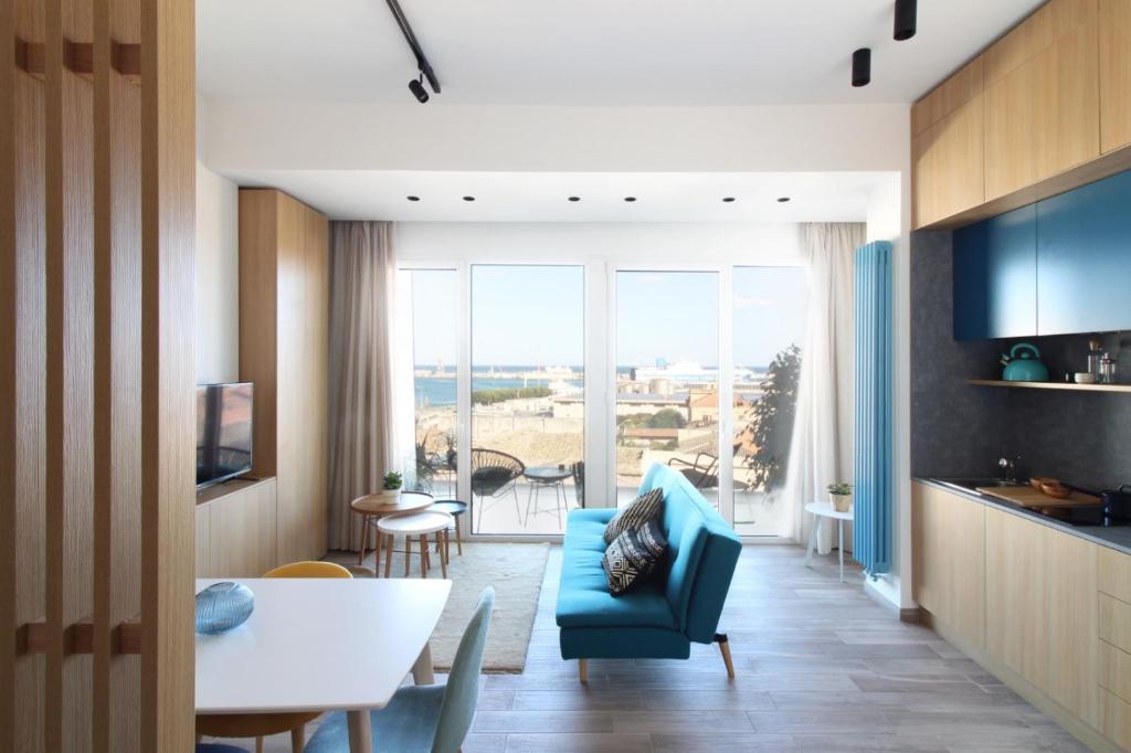 a living room with a blue couch and a table at Seaview Apartments in Palermo