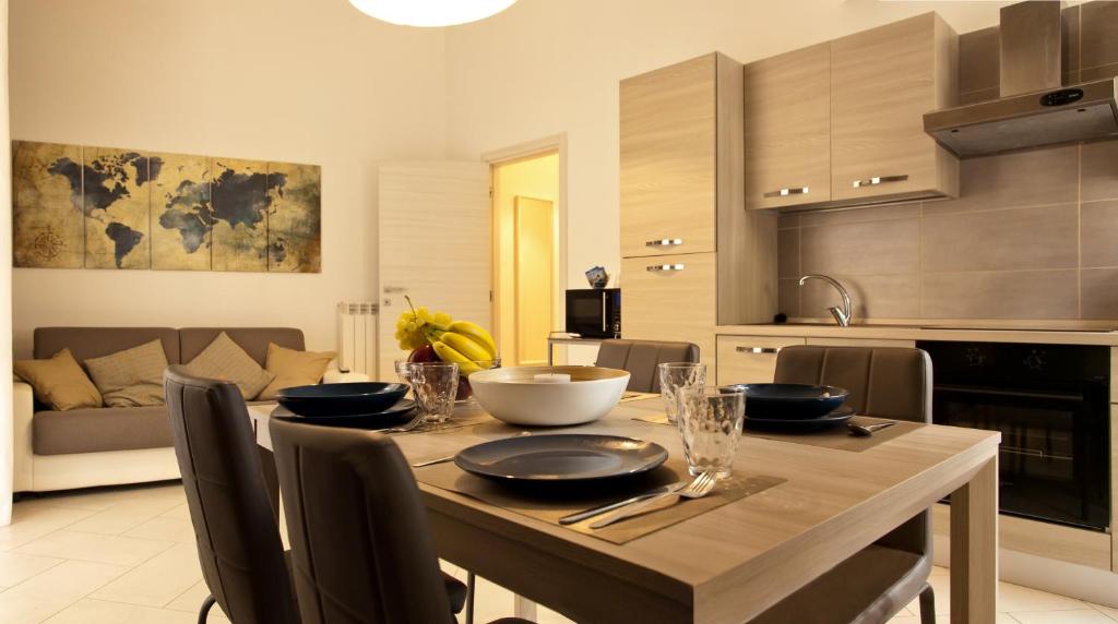 una cucina e una sala da pranzo con tavolo e sedie di Le Corti di Napoli Apartments a Napoli