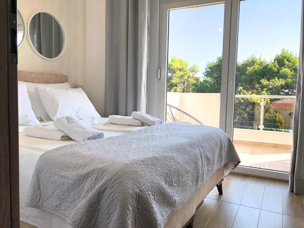 een slaapkamer met een bed en een groot raam bij Apartments M, Kallikratia in Nea Kalikratia