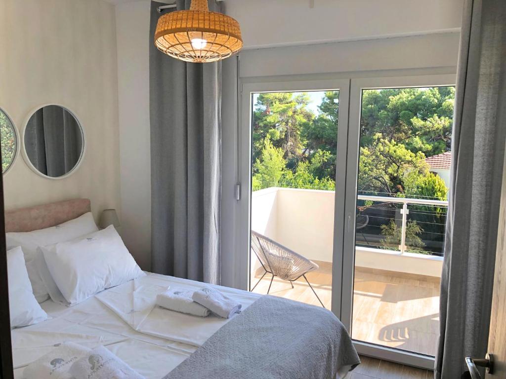 sypialnia z łóżkiem i przesuwanymi drzwiami szklanymi w obiekcie Apartments M, Kallikratia w miejscowości Nea Kallikratia