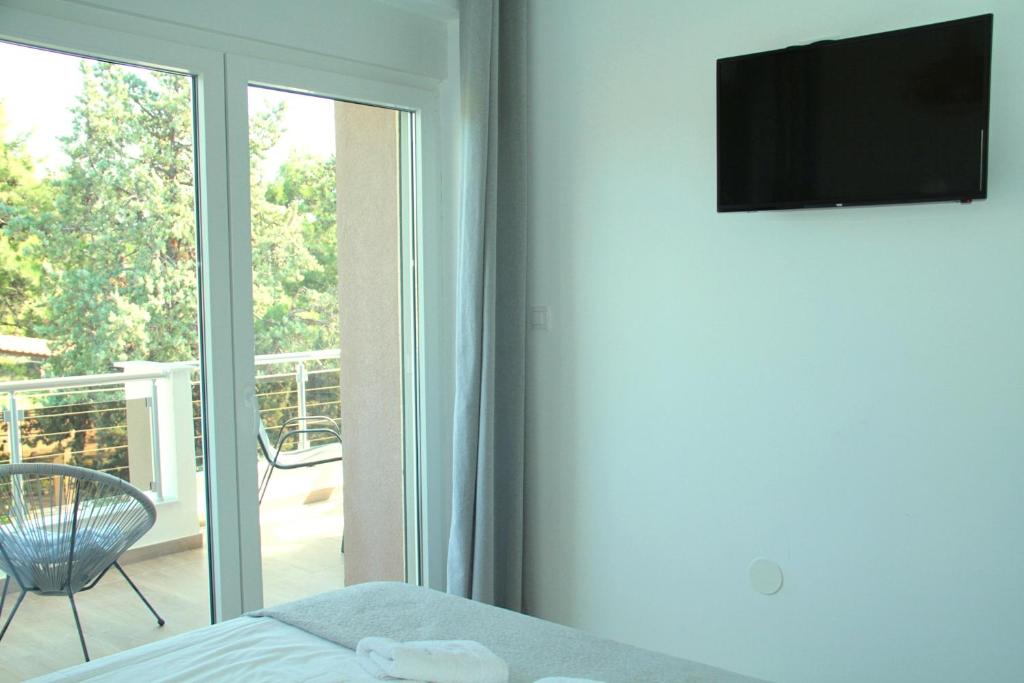 sypialnia z łóżkiem i przesuwanymi drzwiami szklanymi w obiekcie Apartments M, Kallikratia w miejscowości Nea Kallikratia