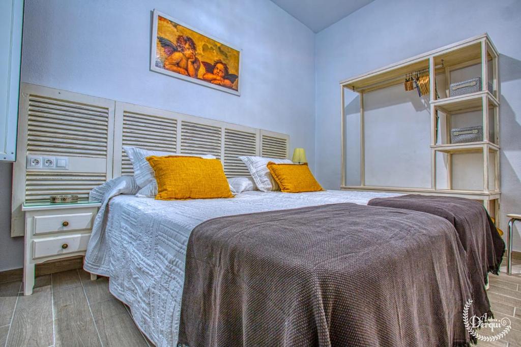 sypialnia z dużym łóżkiem z żółtymi poduszkami w obiekcie CASA ARCO DEL CAÑÓN - Casita con Encanto w mieście Medina Sidonia
