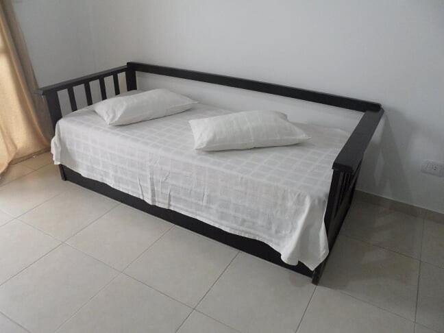 1 cama con 2 almohadas en una habitación en Mercedes Rocamora en Colón