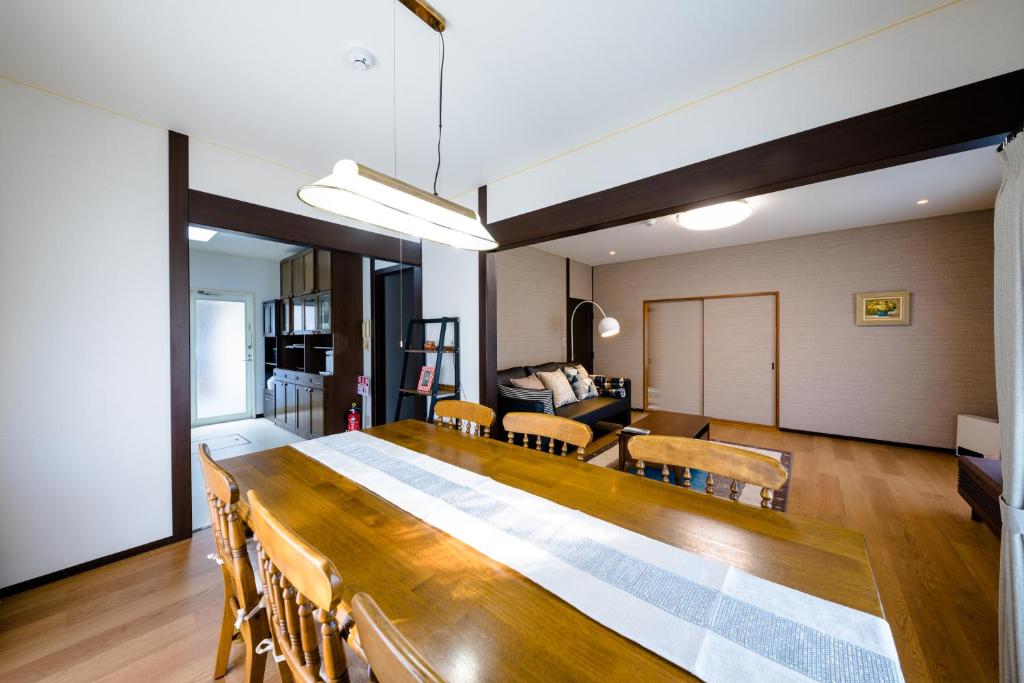 a living room with a large wooden table and chairs at コージー バケーション ステイ 富士河口湖 in Fujikawaguchiko