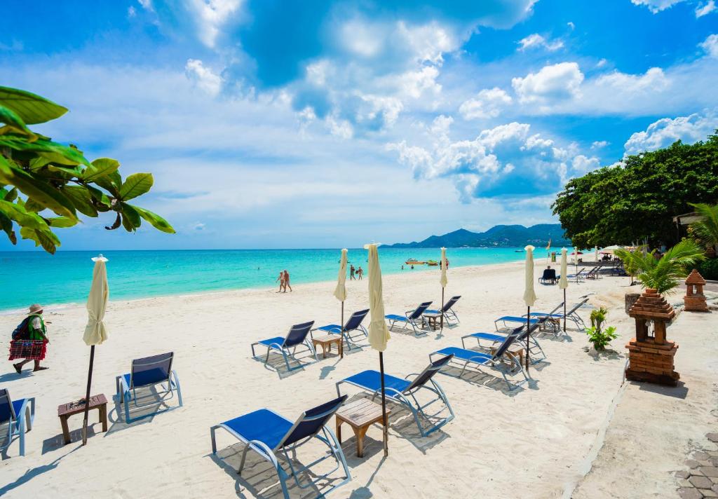 a beach with chairs and umbrellas and the ocean at Chaweng Buri Resort in Chaweng