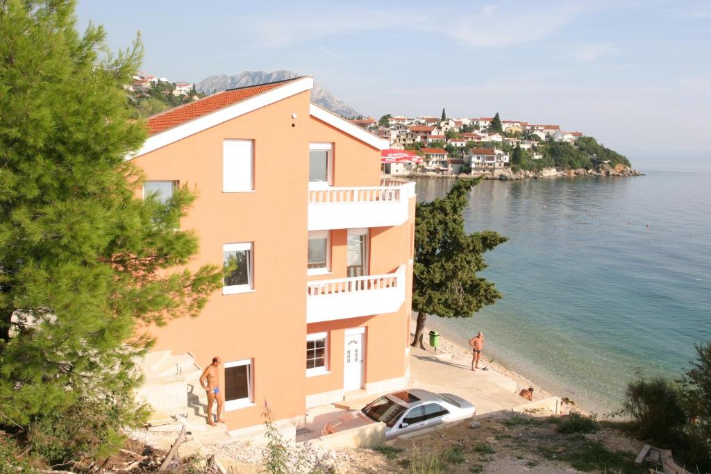 ein Gebäude mit einem Auto neben dem Wasser in der Unterkunft Villa Nelo in Podaca