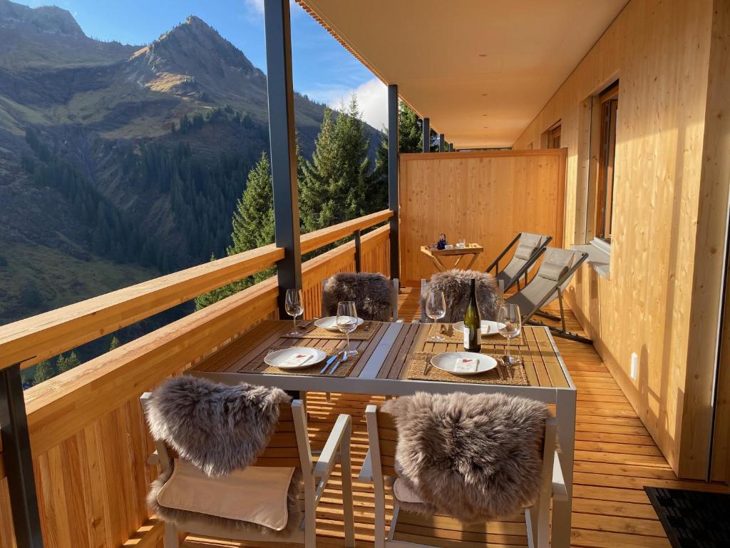 einen Tisch und Stühle auf einem Balkon mit Aussicht in der Unterkunft Landhaus Bergpanorama TOP 7 in Damüls