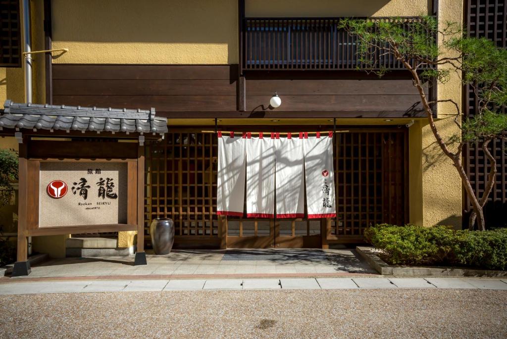 a building with a gate with a white and red curtain at Ryokan Seiryu (Specialised in Hida beef) in Takayama