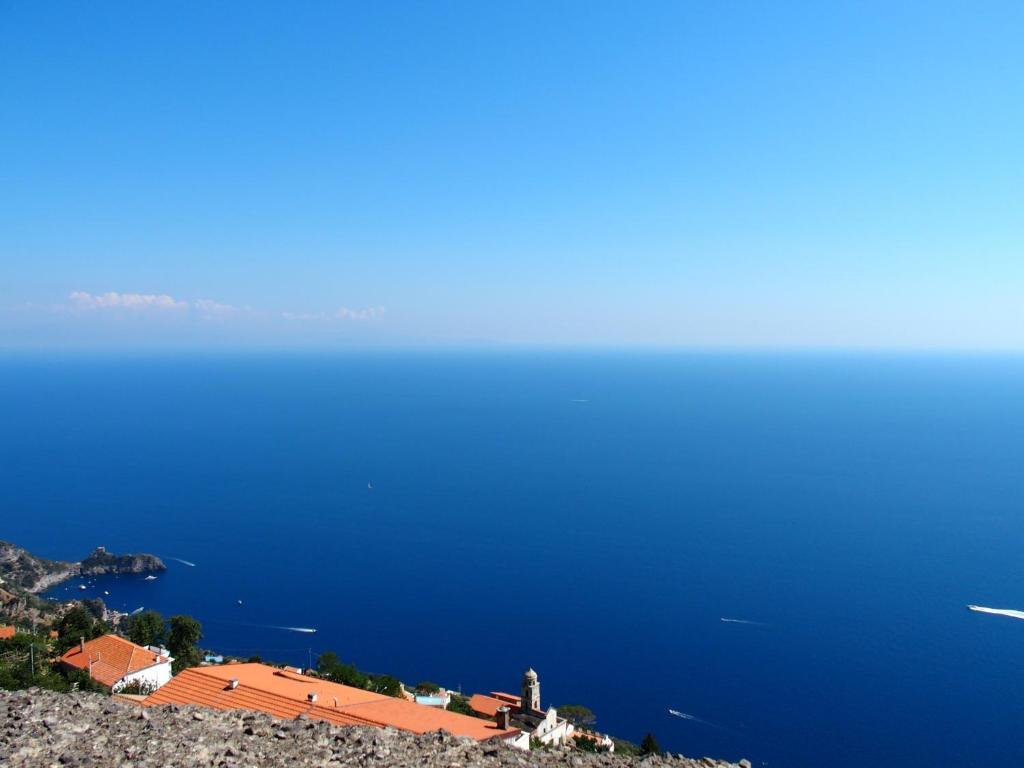 a view of the ocean and a town on a hill at GIARDINO SUL MARE in Amalfi