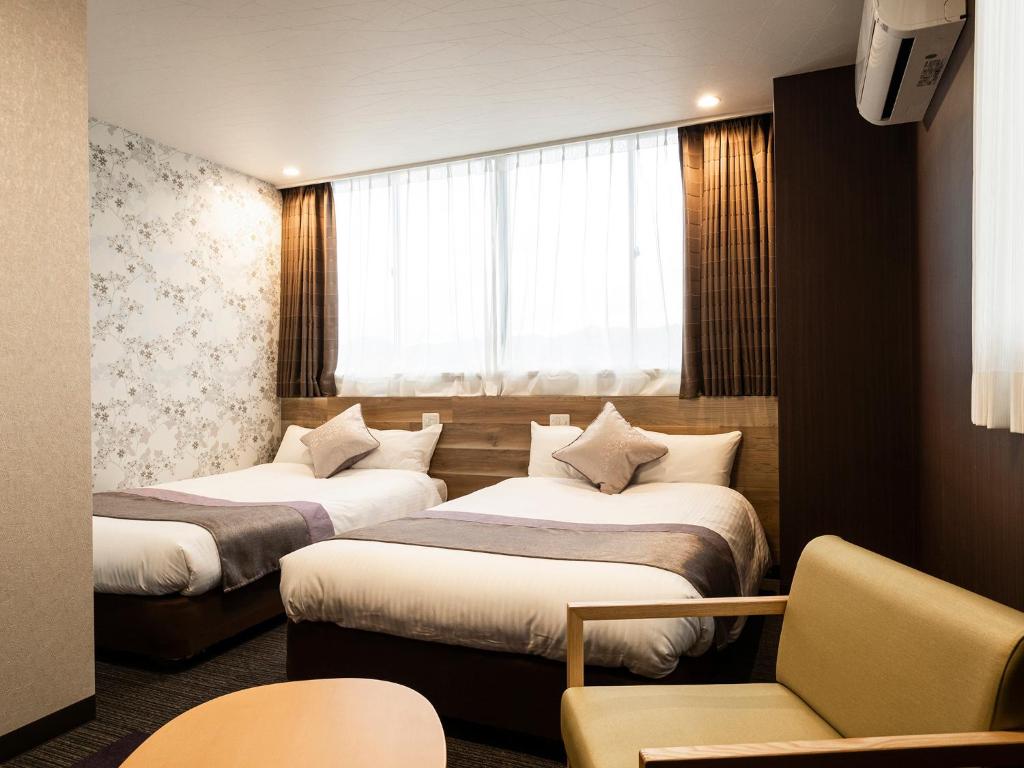 Postel nebo postele na pokoji v ubytování Hotel AreaOne Izumo