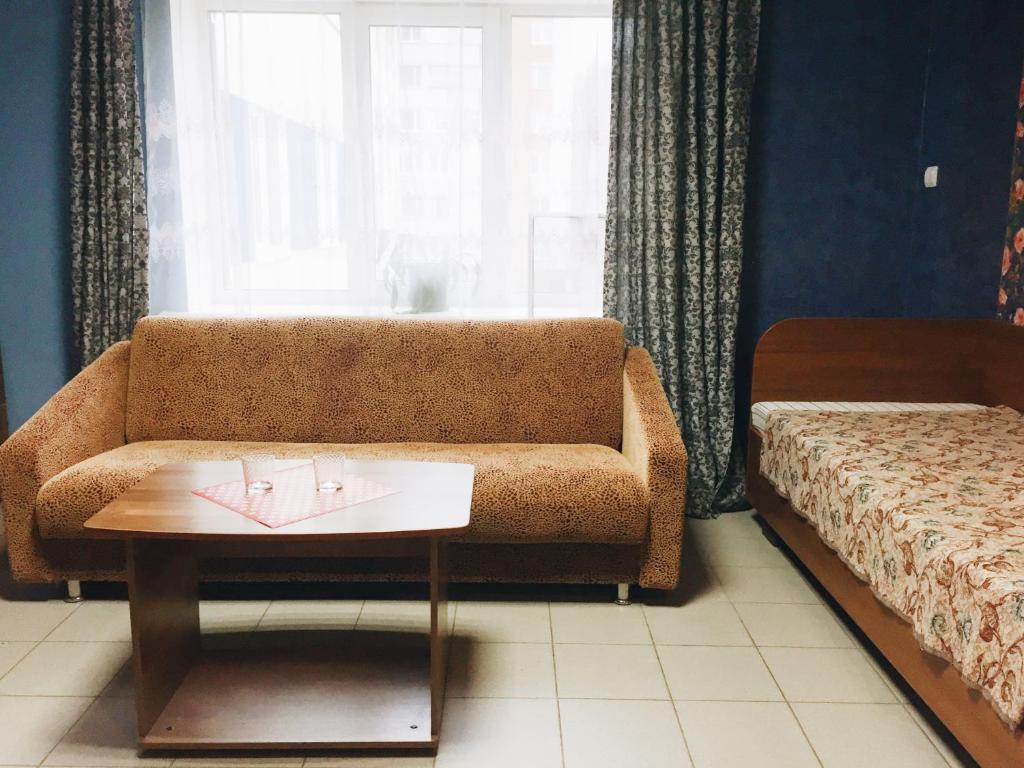 a living room with a couch and a table at Ryabinka Hotel in Cheboksary