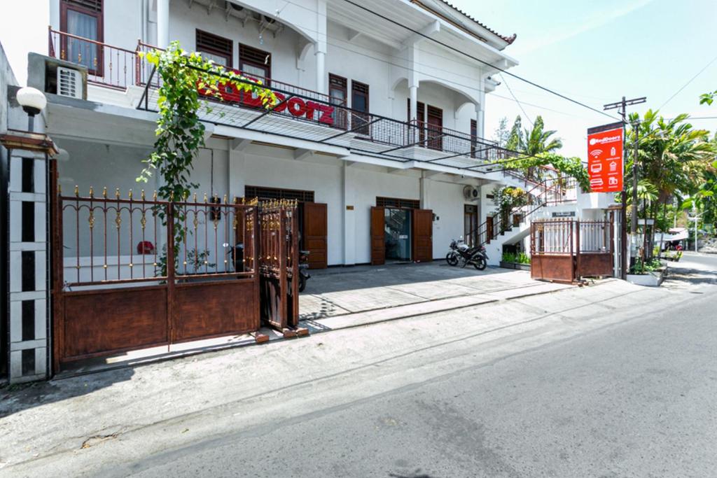 un bâtiment blanc avec une porte dans une rue dans l'établissement RedDoorz near Puro Mangkunegaran, à Solo