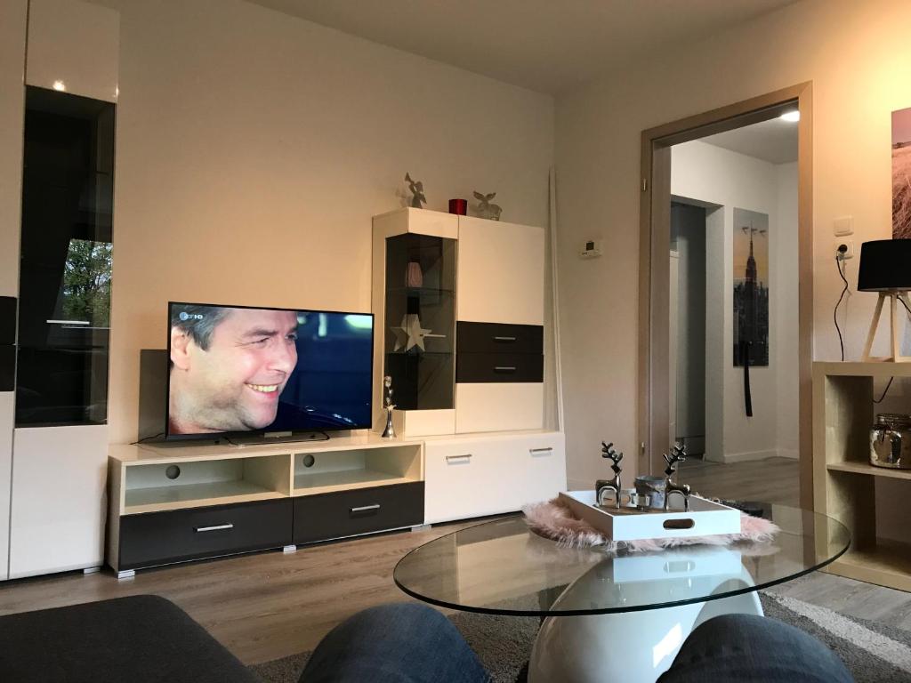 sala de estar con TV y mesa de cristal en Fewo Kerstin, en Oberhausen