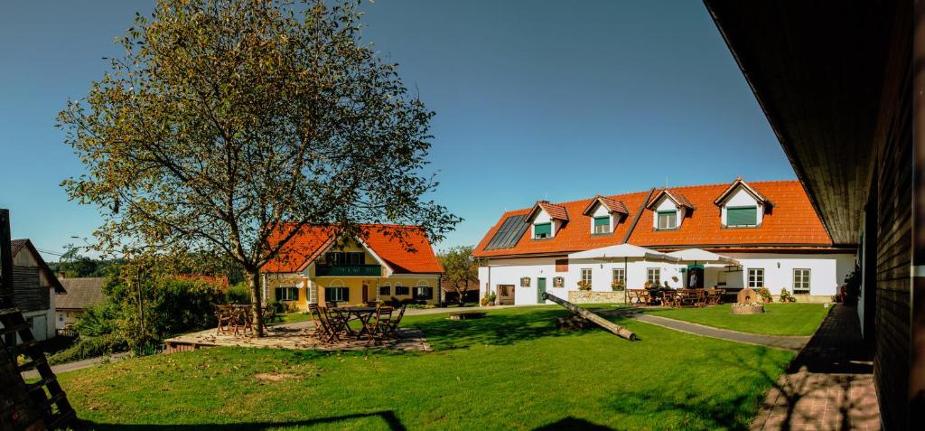 a large house with an orange roof and a yard at Winzerhof Strablegg in Großklein