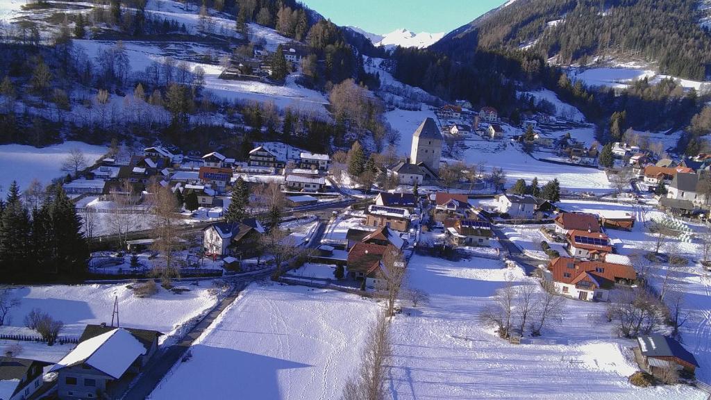 una vista aerea di un piccolo villaggio nella neve di Ferienhaus-Römerthurm a Schöder