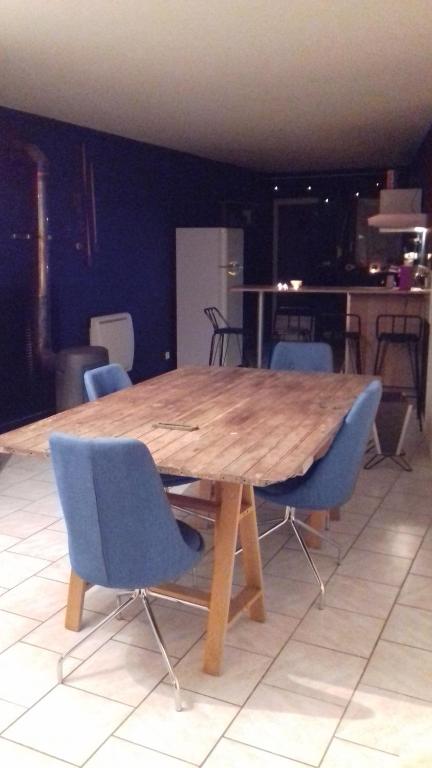 a wooden table with blue chairs in a room at Simple Life House in Saint-Maurice-sous-les-Côtes