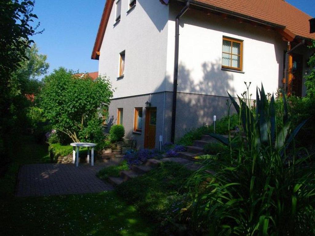 a white house with a garden in front of it at Annettes Ferienstübchen in Bad Berka