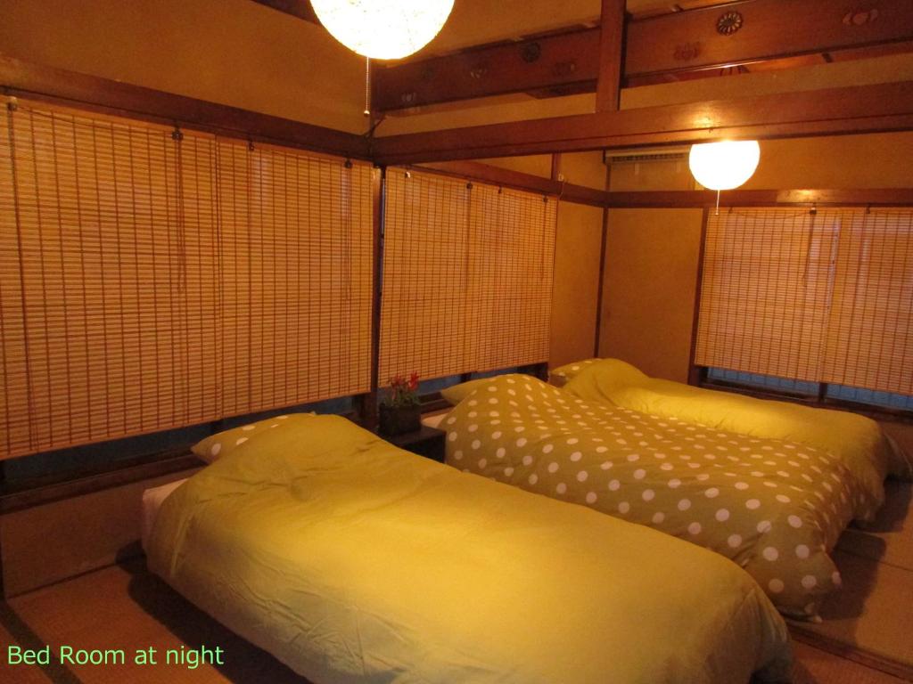 Habitación con 2 camas en una habitación por la noche en ゲストハウス杉田 古民家貸切の完全プライベート空間 杉田駅徒歩2分 セルフチェックイン en Yokohama