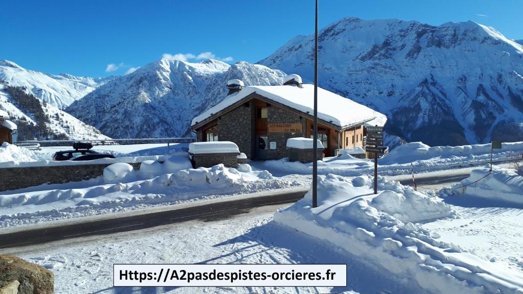 a building covered in snow with mountains in the background at T2 Chalet d'orciéres in Orcières