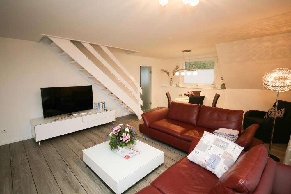 uma sala de estar com um sofá e uma televisão em Ferienwohnung Zweimaster em Travemünde