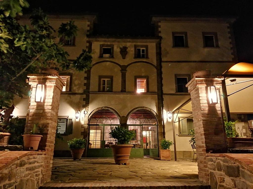 a large building with a courtyard at night at La Fornella dell'Anita in Pelago