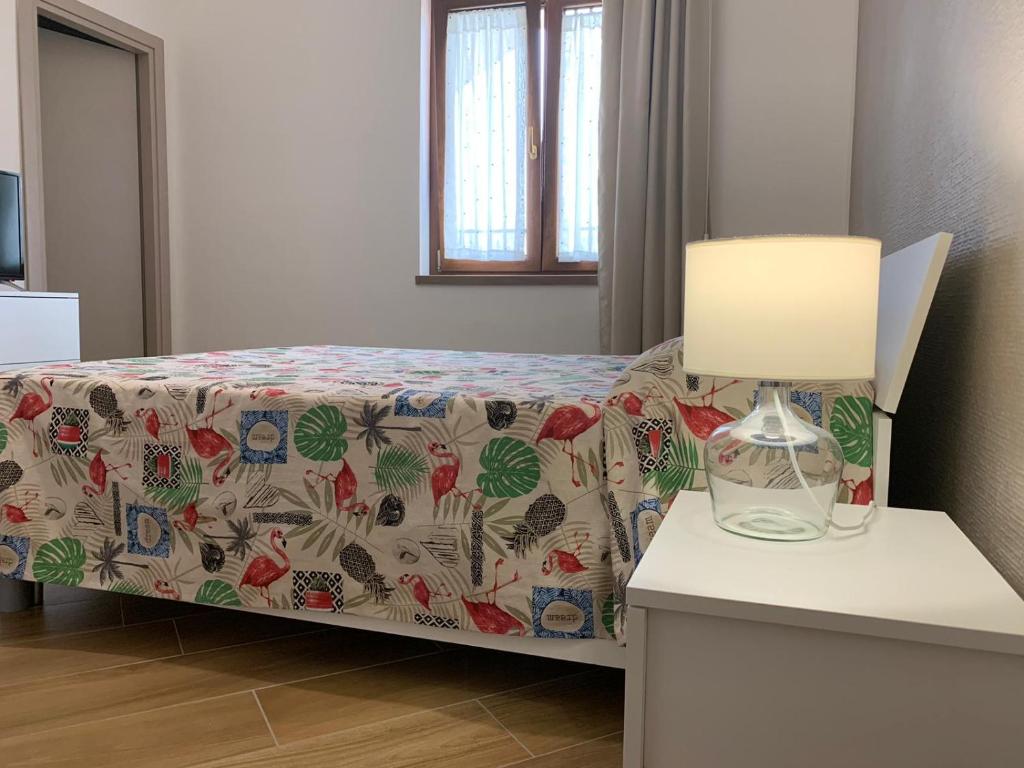 ein Schlafzimmer mit einem Bett und einer Lampe auf einem Tisch in der Unterkunft B&b A casa della nonna in Paestum