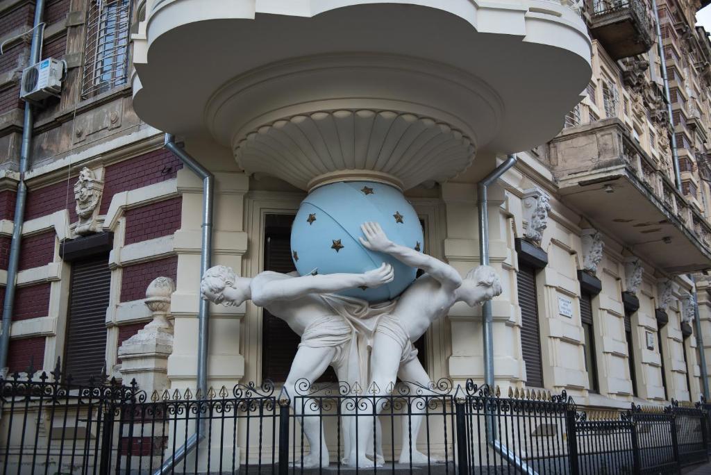 a statue of two men in front of a building at Vip Apartment na Derebasovskoi in Odesa
