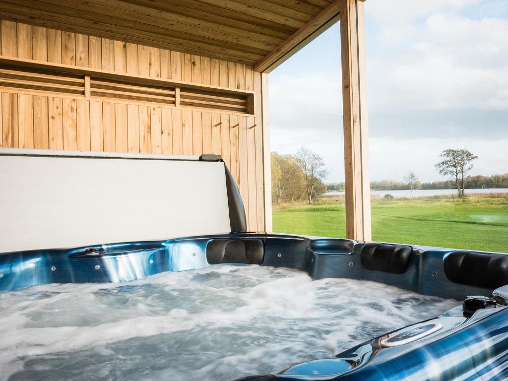 a jacuzzi tub in a house with a window at Platinum Lakeside Lodge at Mullans Bay in Kesh