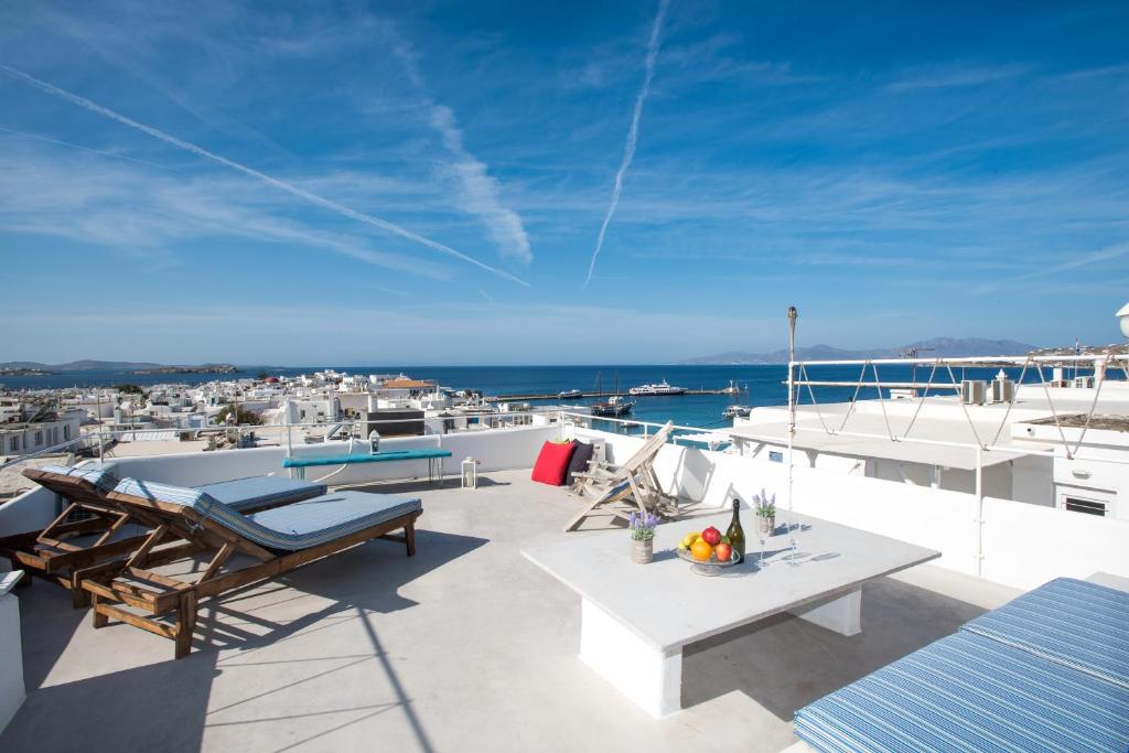Mykonos Panorama with Private Terrace & Sea View في مدينة ميكونوس: شرفة مع طاولة وكراسي والمحيط