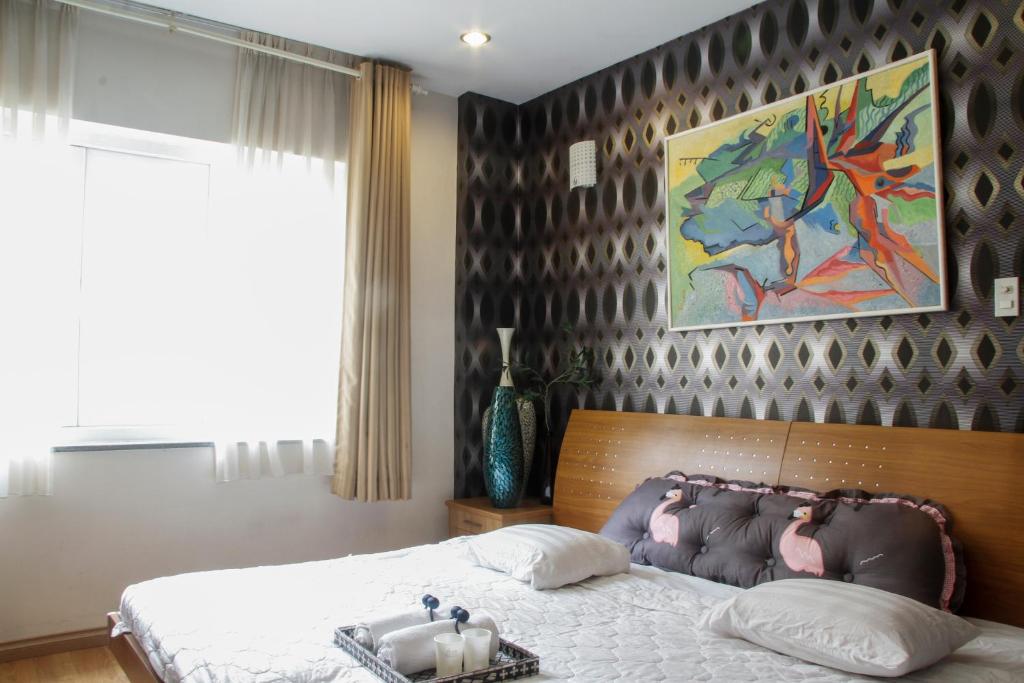 una camera da letto con un letto e un dipinto sul muro di Filippo Saigon ad Ho Chi Minh