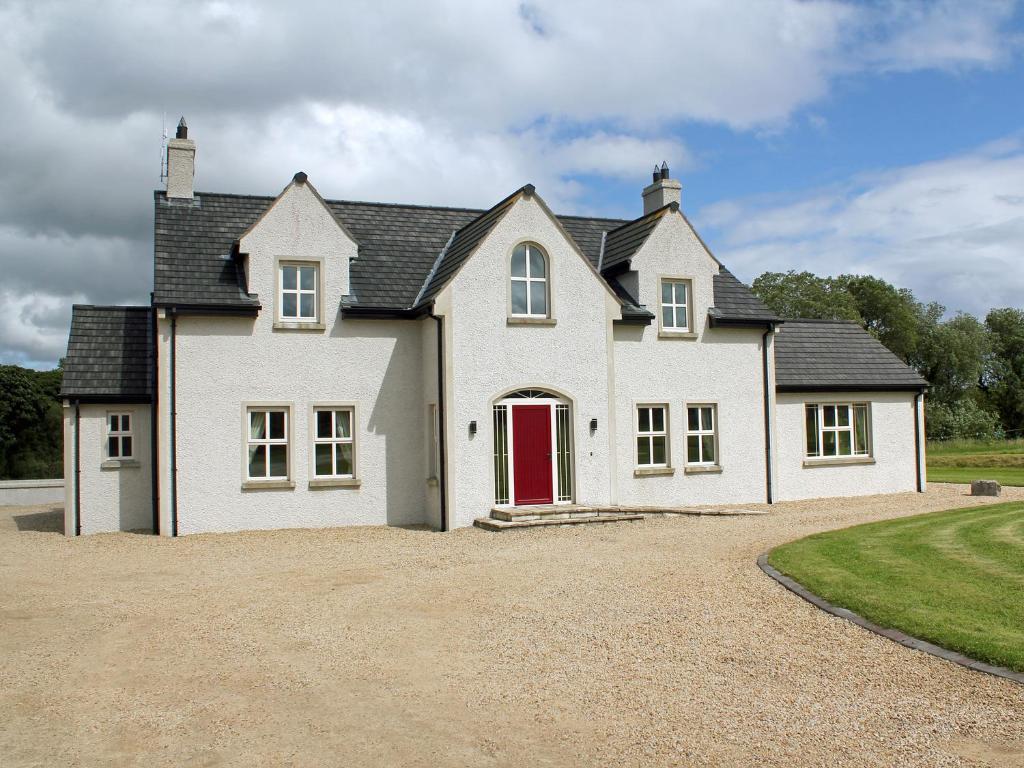 a large white house with a red door at The Willows at Mullans Bay in Kesh