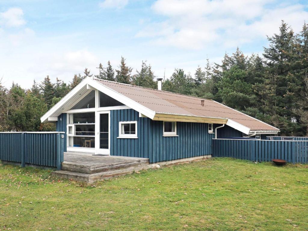 a blue and white house with a fence at Simplistic Holiday Home in Jutland with Swimming Pool in Løkken