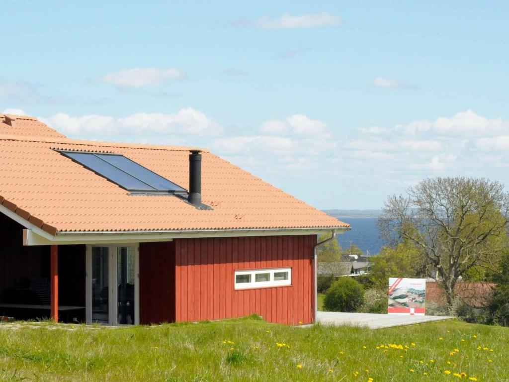 Asserballeskovにある10 person holiday home in Augustenborgの屋根に太陽光パネルを設けた赤い家