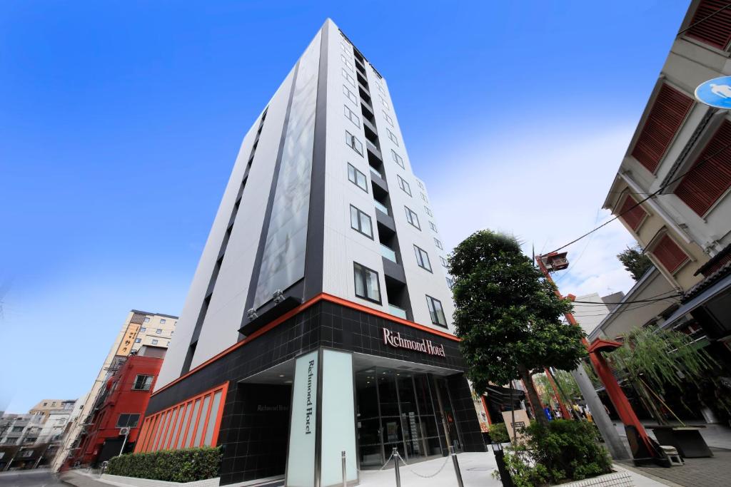 a tall white building on a city street at Richmond Hotel Asakusa in Tokyo