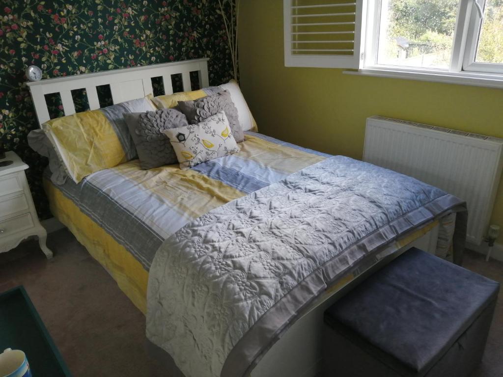 a bed sitting in a room with a window at Charming pink house with perfect location in Whitstable