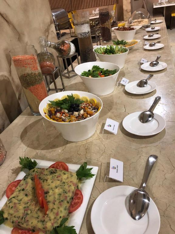 a table with plates of food and bowls of food at Flamingo Beach Hotel in Umm Al Quwain