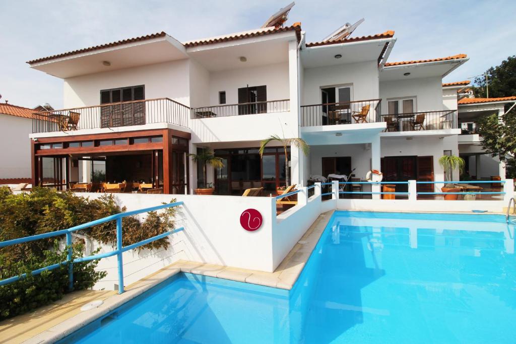 a villa with a swimming pool in front of a house at GuestHouse Vila Lusitania in Funchal