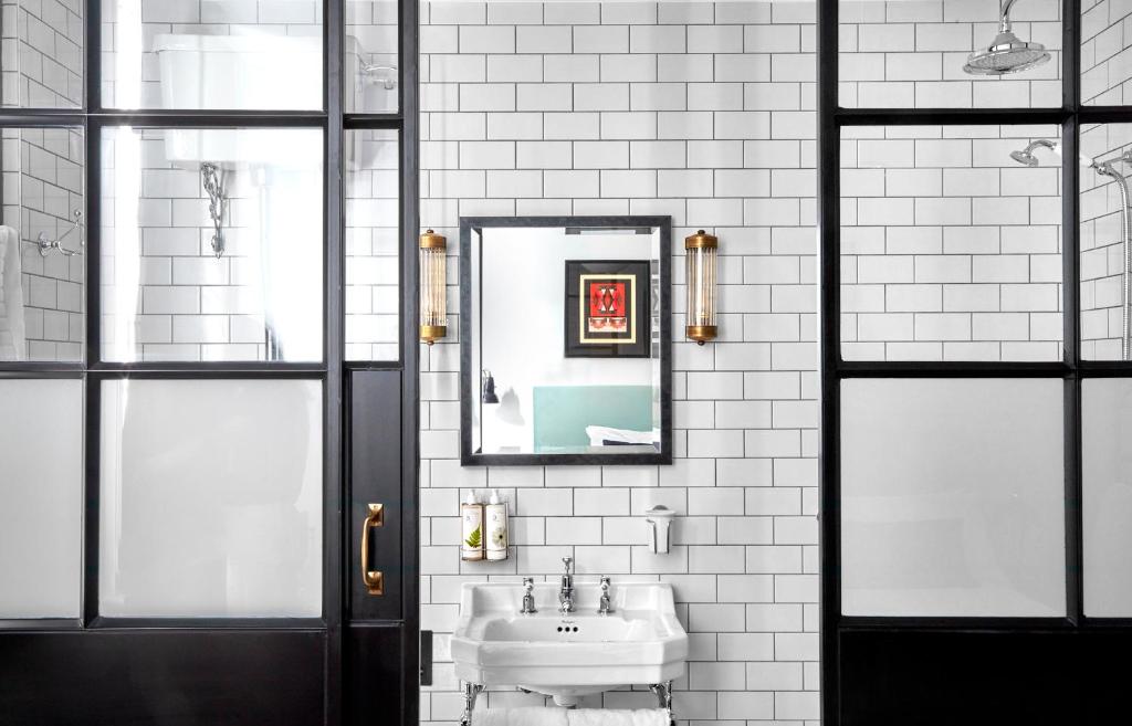 La salle de bains est pourvue d'un lavabo et d'un miroir. dans l'établissement The Coach, à Londres