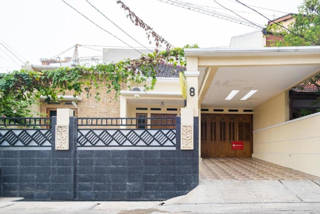une maison avec une clôture noire et blanche dans l'établissement RedDoorz Syariah near Grand Kota Bintang, à Bekasi