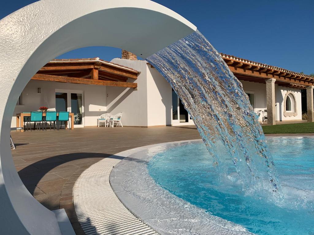 a water fountain in front of a house at VillaLuxx in Porto San Paolo
