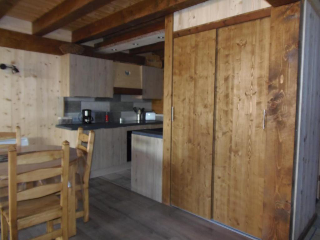 a kitchen with wooden walls and a counter and a table at Chalet l&#39;aubépine résidence B&amp;B in Bessans