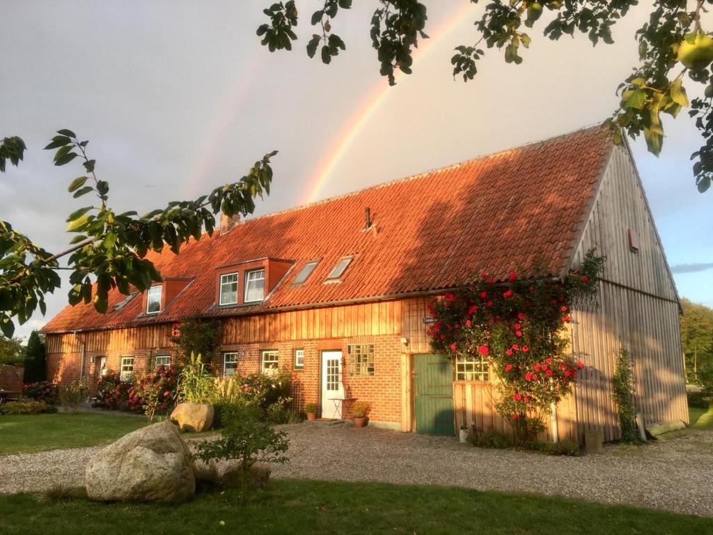 a rainbow over a barn with a house at Ferienvermietung Meerlandliebe in Beschendorf