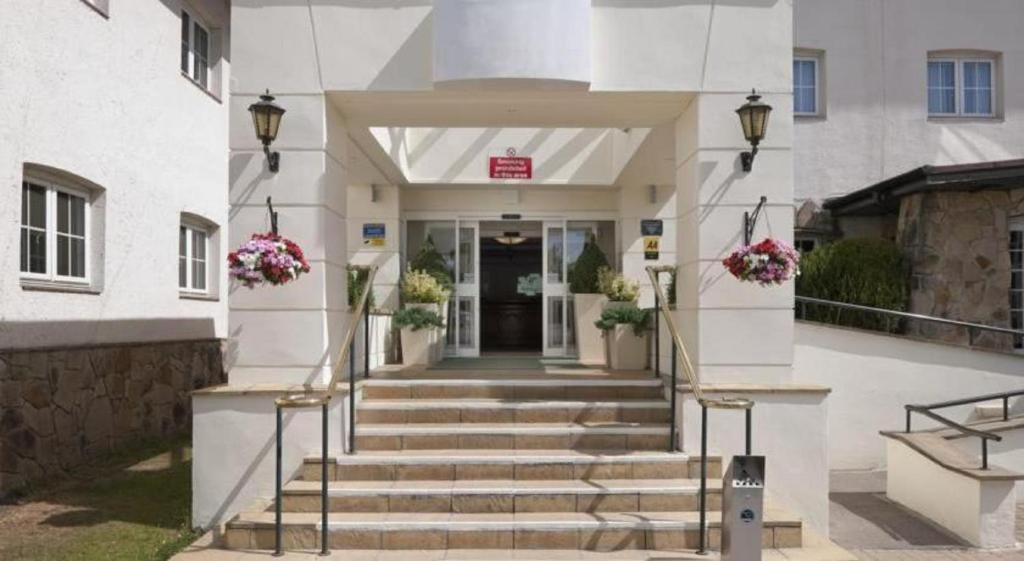 a building with stairs leading to the front door at Airport Inn & Spa Manchester in Wilmslow