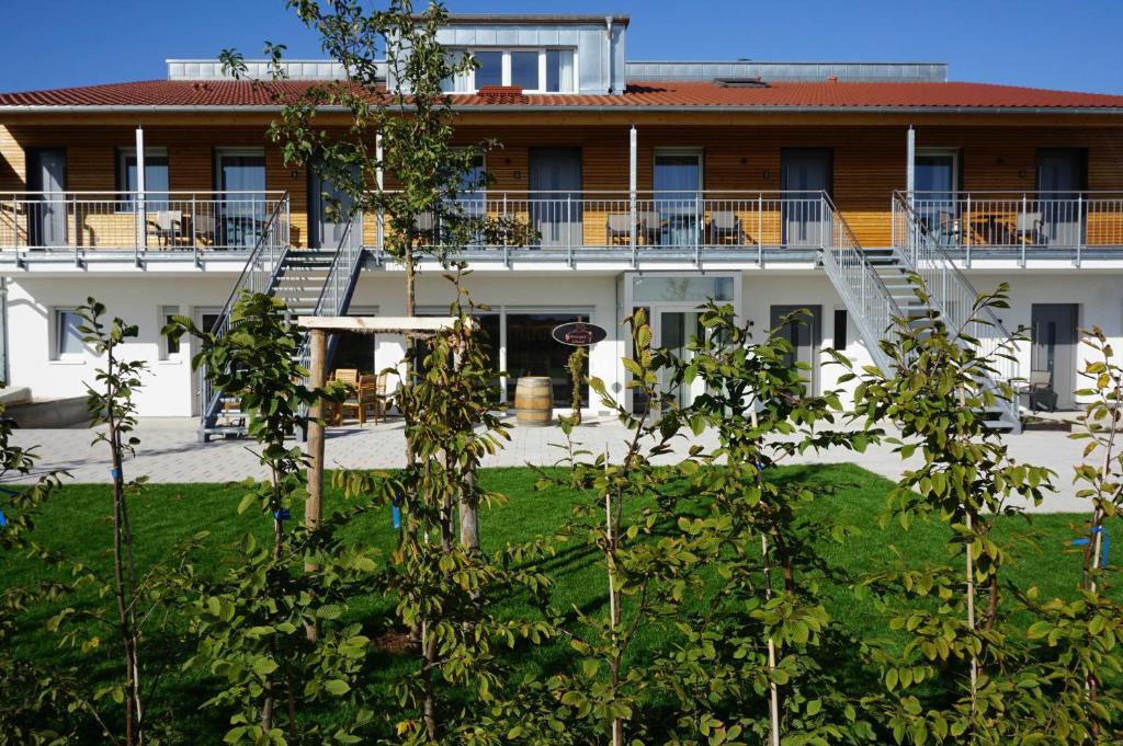 una vista exterior de un edificio con árboles en el primer plano en Weingut Schaaf, en Lauffen am Neckar