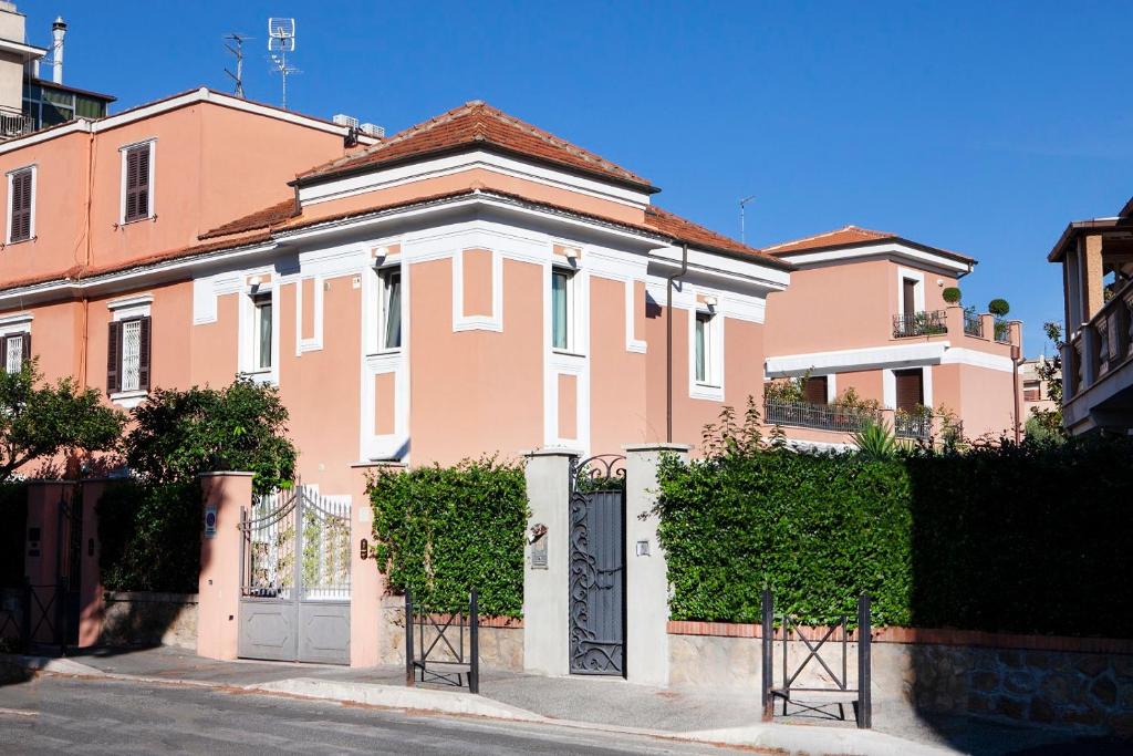 una casa rosa con una puerta delante en I Villini del Pigneto, en Roma