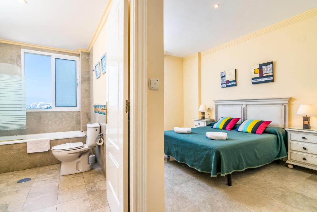 a bedroom with a bed and a bathroom with a toilet at Banana Beach in Marbella